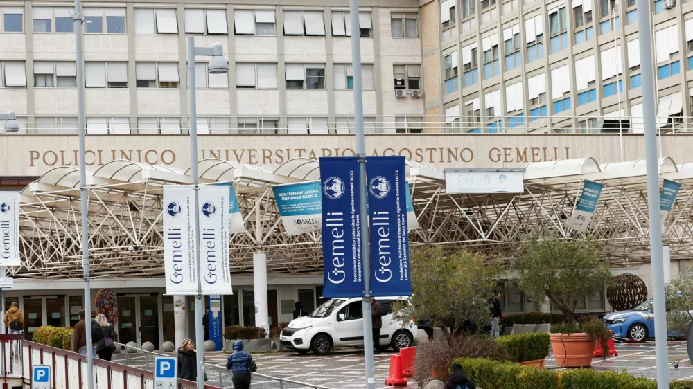 People walk outside the Gemelli Hospital where Pope Francis is hospitalised for bronchitis treatment in Rome, Italy, February 15, 2025. REUTERS/Ciro De Luca