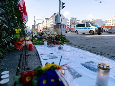 15 February 2025, Bavaria, Munich: A police emergency vehicle drives past flowers placed near the spot where a car drove into a group of demonstrators in Munich's city center last Thursday. The 24-year-old suspect in Thursday's vehicle attack in Munich confessed to intentionally crashing his car into a trade union rally, injuring at least 39 people, and investigators believe he acted out of an "Islamist motive," a senior Munich public prosecutor said on Friday. Photo: Pia Bayer/dpa