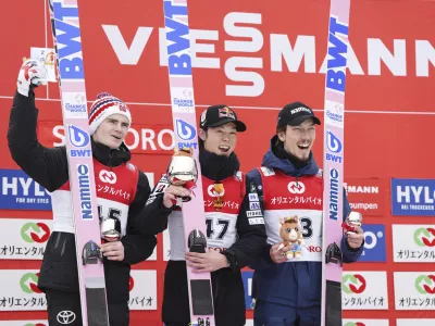 Japan's Royu Kobayashi, center, second placed Marius Lindvik of Norway, and third placed Johann Forfang of Norway pose together on the podium during the men's Ski Jumping World Cup event in Sapporo, northern Japan Sunday, Feb. 16, 2025. (Kyodo News via AP)