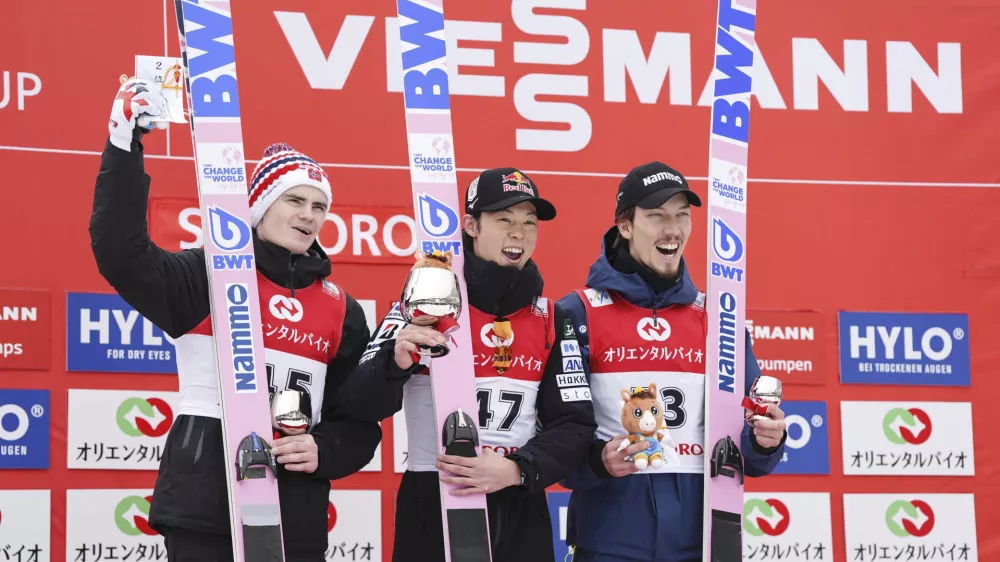 Japan's Royu Kobayashi, center, second placed Marius Lindvik of Norway, and third placed Johann Forfang of Norway pose together on the podium during the men's Ski Jumping World Cup event in Sapporo, northern Japan Sunday, Feb. 16, 2025. (Kyodo News via AP)