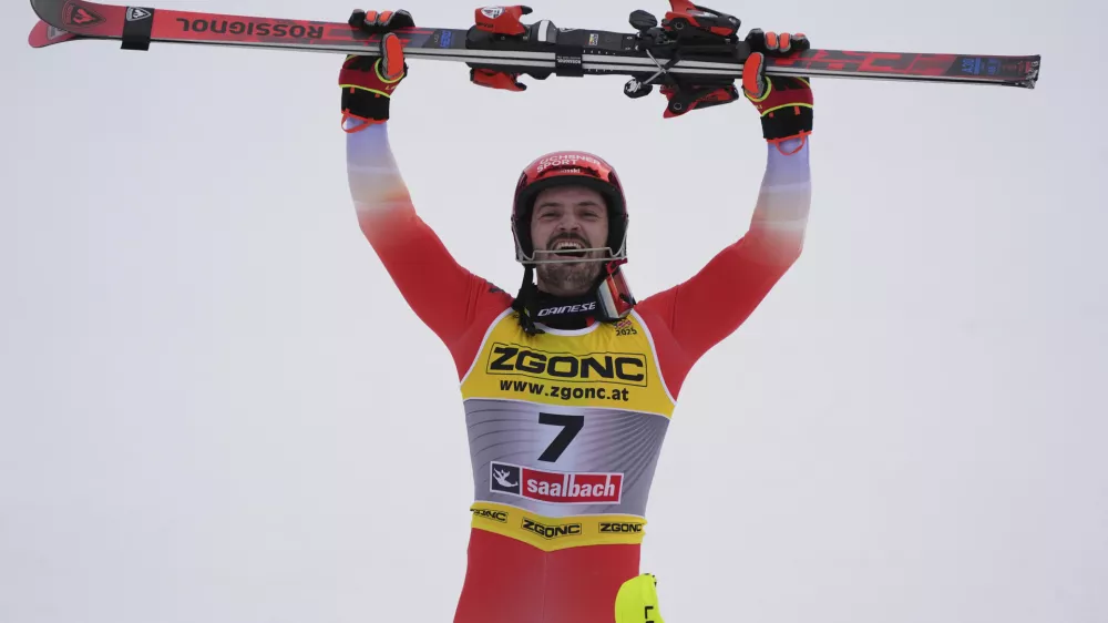 Switzerland's Loic Meillard celebrates winning the gold medal in a men's slalom, at the Alpine Ski World Championships, in Saalbach-Hinterglemm, Austria, Sunday, Feb. 16, 2025. (AP Photo/Giovanni Auletta)