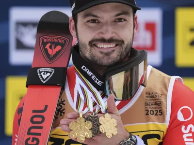 Switzerland's Loic Meillard shows his gold medals for a men's slalom and for team combined event, left, and right, and a bronze medal for a giant slalom center, at the Alpine Ski World Championships, in Saalbach-Hinterglemm, Austria, Sunday, Feb. 16, 2025. (AP Photo/Giovanni Auletta)