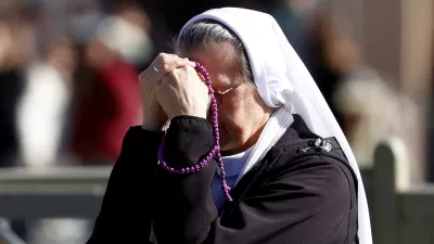 A nun prays at Saint Peter's Square while Pope Francis is hospitalized for bronchitis treatment at the Vatican, February 16, 2025. REUTERS/Ciro De Luca   TPX IMAGES OF THE DAY