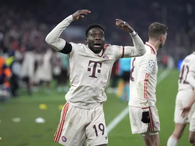 Bayern's Alphonso Davies, centre, celebrates after scoring his side's opening goal during the Champions League playoff second leg soccer match between FC Bayern Munich and Celtic Glasgow at the Allianz Arena in Munich, Germany, Tuesday, Feb. 18, 2025. (AP Photo/Matthias Schrader)