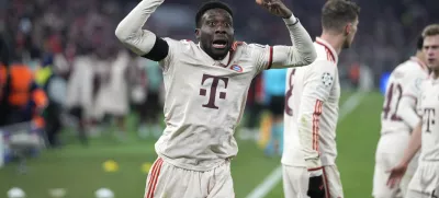 Bayern's Alphonso Davies, centre, celebrates after scoring his side's opening goal during the Champions League playoff second leg soccer match between FC Bayern Munich and Celtic Glasgow at the Allianz Arena in Munich, Germany, Tuesday, Feb. 18, 2025. (AP Photo/Matthias Schrader)