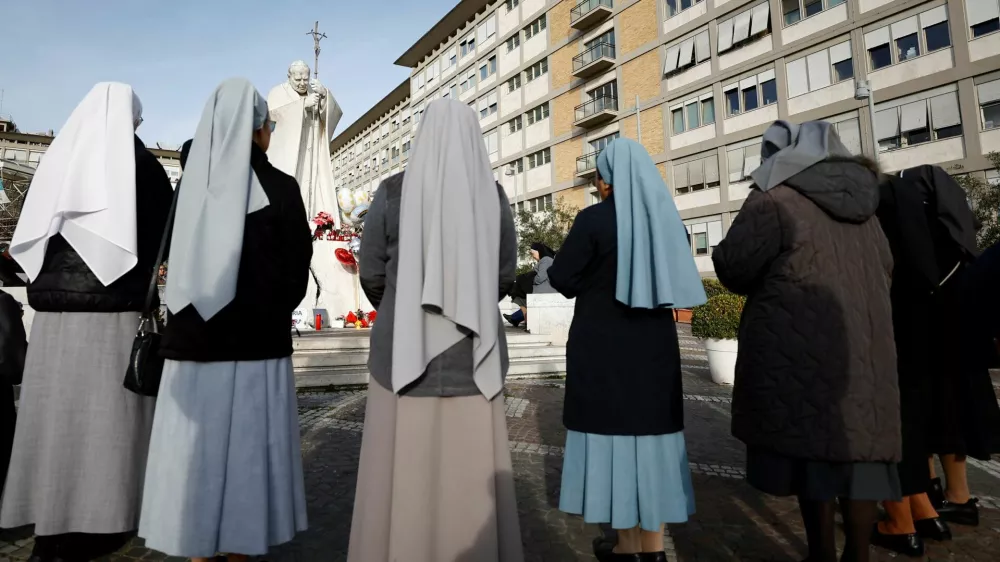 Nuns pray outside the Gemelli Hospital where Pope Francis is admitted for treatment, in Rome, Italy, February 23, 2025. REUTERS/Vincenzo Livieri