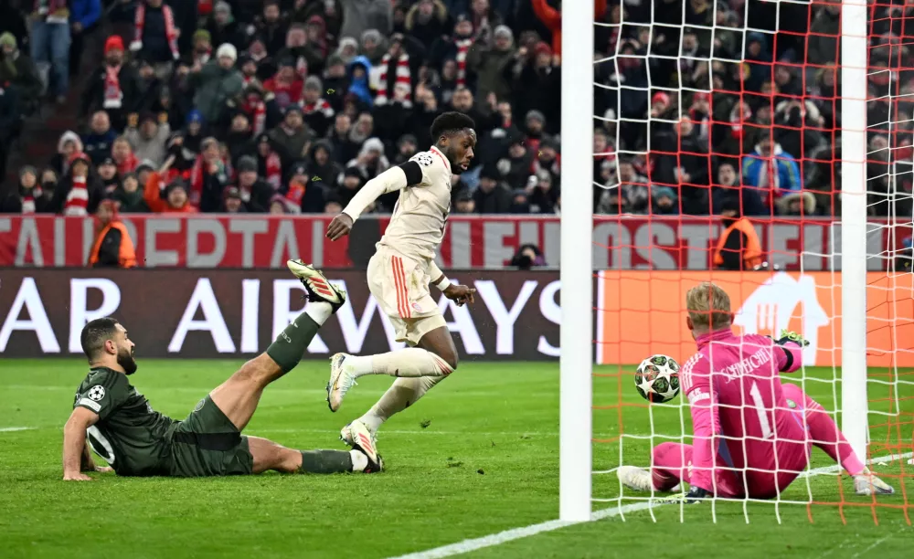 Soccer Football - Champions League - Knockout Phase Playoff - Second Leg - Bayern Munich v Celtic - Allianz Arena, Munich, Germany - February 18, 2025 Bayern Munich's Alphonso Davies scores their second goal past Celtic's Kasper Schmeichel REUTERS/Angelika Warmuth   TPX IMAGES OF THE DAY