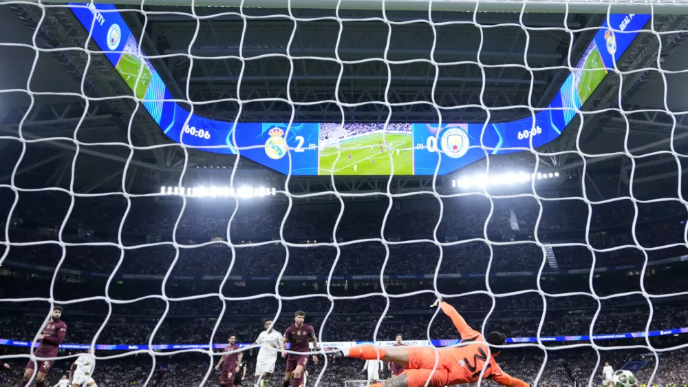 Manchester City's goalkeeper Ederson fails to make a save against a shot by Real Madrid's Kylian Mbappe during the Champions League playoff second leg soccer match between Real Madrid and Manchester City at the Santiago Bernabeu Stadium in Madrid, Spain, Wednesday, Feb. 19, 2025. (AP Photo/Manu Fernandez)