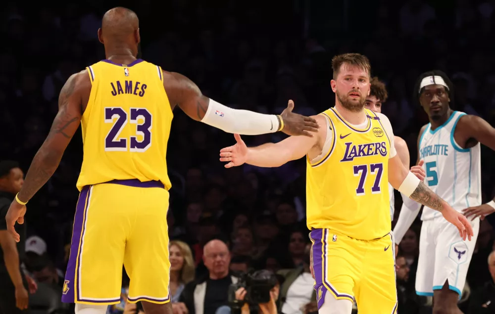 Feb 19, 2025; Los Angeles, California, USA; Los Angeles Lakers forward LeBron James (23) and guard Luka Doncic (77) celebrate after a play during the third quarter against the Charlotte Hornets at Crypto.com Arena. Mandatory Credit: Jason Parkhurst-Imagn Images