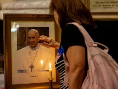 19 February 2025, Argentina, Buenos Aires: A woman stands in front of Pope Francis' picture during a mass held for his health in the Basilica of San Jose de Flores. Photo: Cristina Sille/dpa