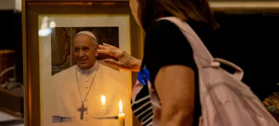 19 February 2025, Argentina, Buenos Aires: A woman stands in front of Pope Francis' picture during a mass held for his health in the Basilica of San Jose de Flores. Photo: Cristina Sille/dpa