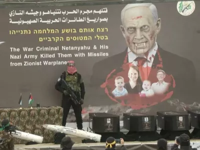 A Hamas militant stands near coffins during the handover of deceased hostages Oded Lifschitz, Shiri Bibas and her two children Kfir and Ariel Bibas, seized during the deadly October 7, 2023 attack, to the Red Cross, as part of a ceasefire and hostages-prisoners swap deal between Hamas and Israel, in Khan Younis in the southern Gaza Strip, in this still image taken from a video February 20, 2025. REUTERS/REUTERS TV