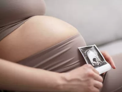 2JHB1WA Pregnant woman belly. Pregnancy Concept. Pregnant tummy close up. Detail of pregnant woman relaxing on comfortable sofa at home. Foto: Reuters/Alamy