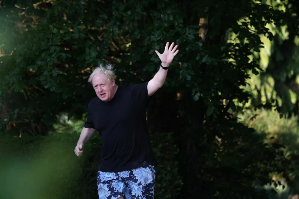 Former British Prime Minister Boris Johnson gestures as he runs near his home in Brightwell-cum-Sotwell, Oxfordshire, Britain, June 15, 2023. REUTERS/Toby Melville