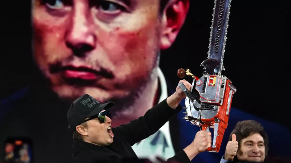 21 February 2025, US, Oxen Hill: Elon Musk is given a chainsaw as a gift by Argentine President Javier Millei during his appearance at CPAC, the annual Conservative Political Action Conference at the Gaylord Convention Center in Oxen Hill MD. Photo: Carol Guzy/ZUMA Press Wire/dpa