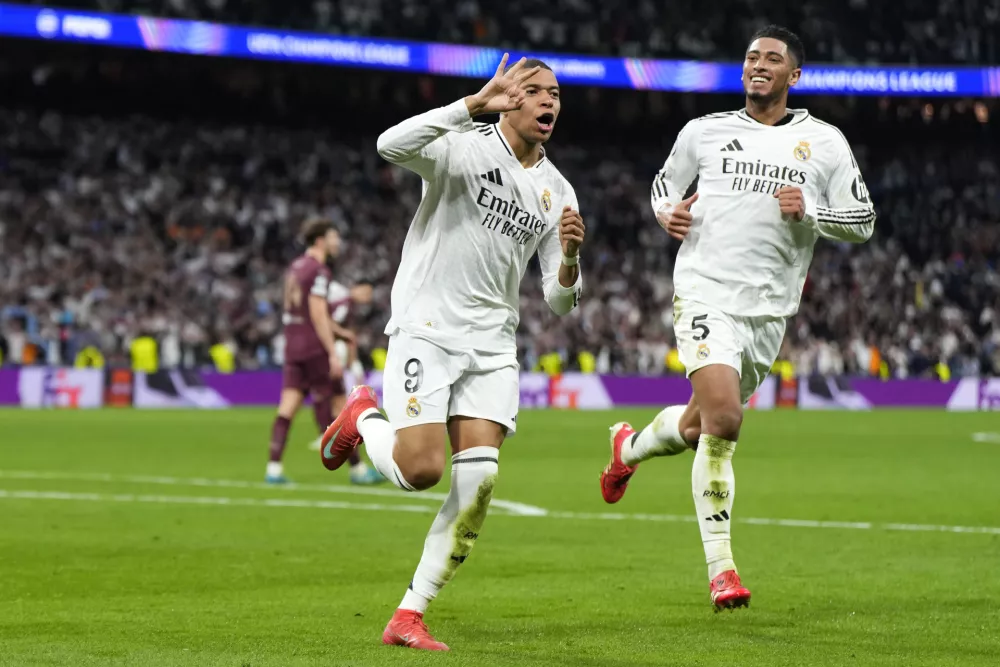 Real Madrid's Kylian Mbappe celebrates with Real Madrid's Jude Bellingham, right, after scoring his sides third goal during the Champions League playoff second leg soccer match between Real Madrid and Manchester City at the Santiago Bernabeu Stadium in Madrid, Spain, Wednesday, Feb. 19, 2025. (AP Photo/Manu Fernandez)