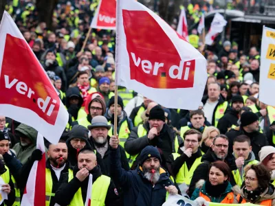 21 February 2025, Berlin: Members of various professions demonstrate with Verdi flags at a rally in front of the Rotes Rathaus. Verdi calls for a warning strike at Stromnetz Berlin, BEW Berliner Energie und Wärme, Berliner Stadtreinigung and Berliner Wasserbetriebe on the occasion of collective bargaining for more than 2.5 million public sector employees at federal and municipal level. Photo: Carsten Koall/dpa