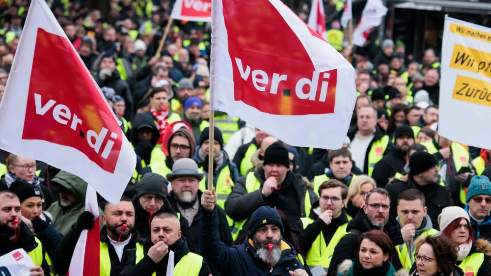 21 February 2025, Berlin: Members of various professions demonstrate with Verdi flags at a rally in front of the Rotes Rathaus. Verdi calls for a warning strike at Stromnetz Berlin, BEW Berliner Energie und Wärme, Berliner Stadtreinigung and Berliner Wasserbetriebe on the occasion of collective bargaining for more than 2.5 million public sector employees at federal and municipal level. Photo: Carsten Koall/dpa