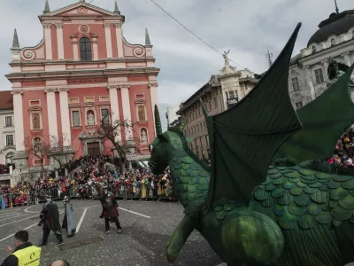 ﻿- maskota karnevala - zmaj, Frančiškanska cerkev - Prešernov trg - - Zmajev karneval v Ljubljani 2014 - pustni karneval na ljubljanskih ulicah posvečen 2000-letnici rimske Emone - pustne maske - pust - pustovanje   //FOTO: Luka Cjuha.