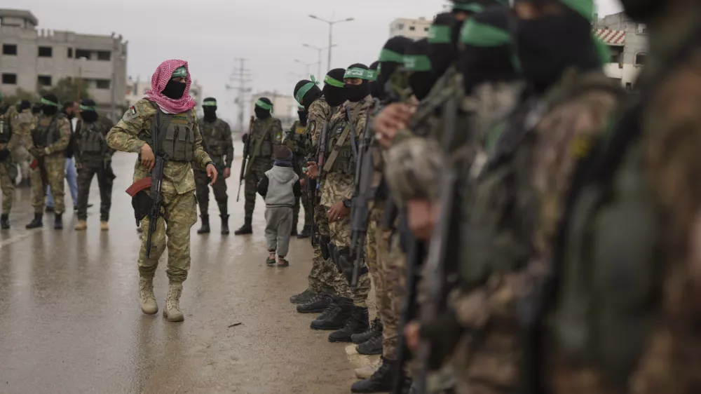 CORRECTS THE NAME OF THE CITY AS NUSEIRAT - Hamas fighters stand in formation ahead of the planned release of Israeli hostages set to be handed over to the Red Cross in Nuseirat, Gaza Strip, Saturday, Feb. 22, 2025. (AP Photo/Abdel Kareem Hana)