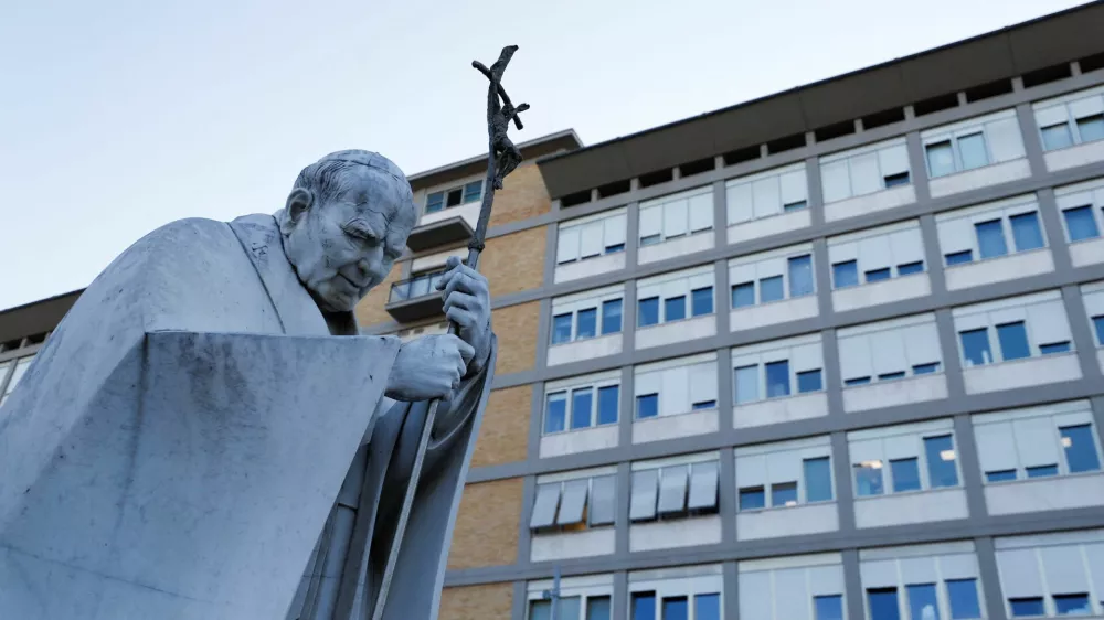 The statue of the late Pope John Paul II stands outside the Gemelli Hospital, where Pope Francis is admitted for treatment, in Rome, Italy, February 22, 2025. REUTERS/Ciro De Luca