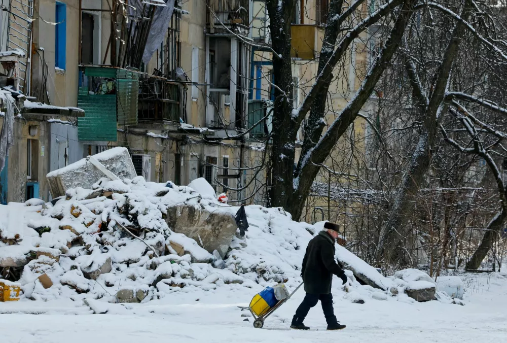 A man pulls a cart near a building damaged in the course of Russia-Ukraine conflict in Avdiivka (Avdeyevka), a Russian controlled region of Ukraine February 16, 2025. REUTERS/Alexander Ermochenko