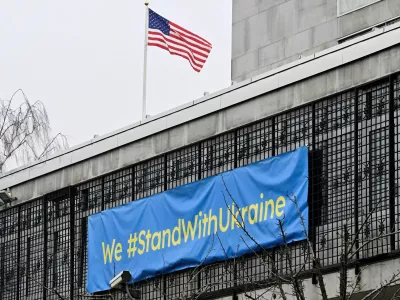 U.S. flag flutters next to a banner that reads "We #StandWithUkraine" at the U.S. embassy in Stockholm, Sweden February 22, 2025. TT News Agency/Jonas Ekstromer/via REUTERS   ATTENTION EDITORS - THIS IMAGE WAS PROVIDED BY A THIRD PARTY. SWEDEN OUT. NO COMMERCIAL OR EDITORIAL SALES IN SWEDEN.