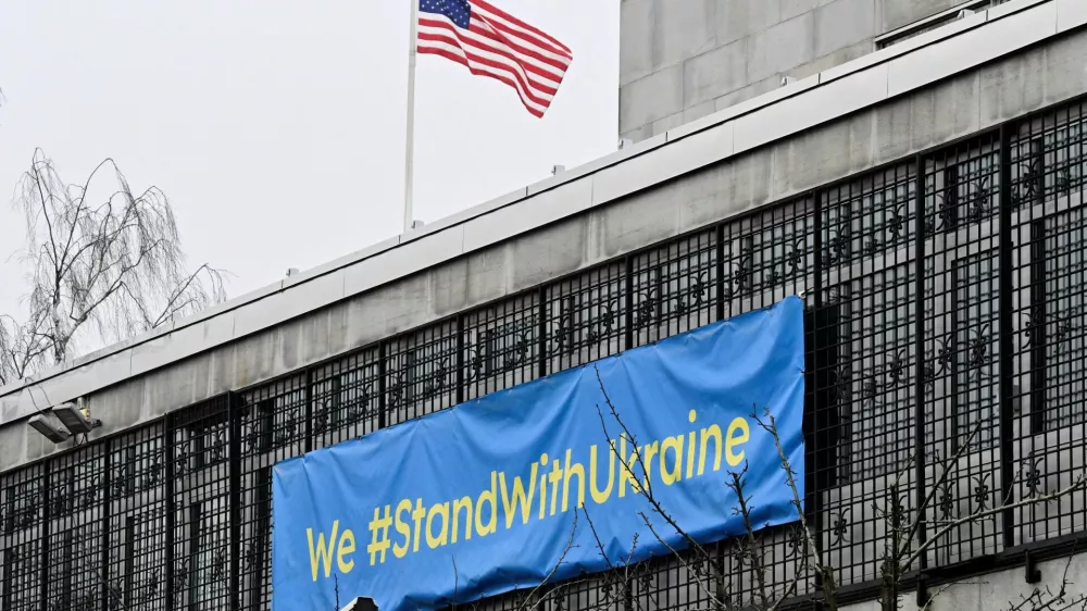 U.S. flag flutters next to a banner that reads "We #StandWithUkraine" at the U.S. embassy in Stockholm, Sweden February 22, 2025. TT News Agency/Jonas Ekstromer/via REUTERS   ATTENTION EDITORS - THIS IMAGE WAS PROVIDED BY A THIRD PARTY. SWEDEN OUT. NO COMMERCIAL OR EDITORIAL SALES IN SWEDEN.