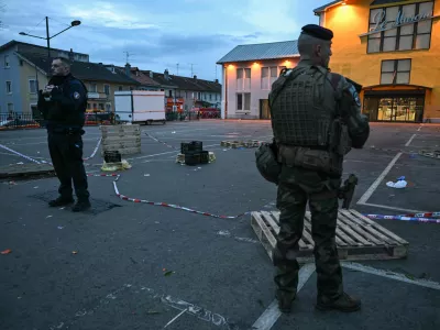 22 February 2025, France, Mulhouse: A police officer and a soldier stand at the site of a knife attack in Mulhouse. A man is suspected of killing one person and wounding two municipal police officers at a market in Mulhouse. Photo: Sebastien Bozon/AFP/dpa