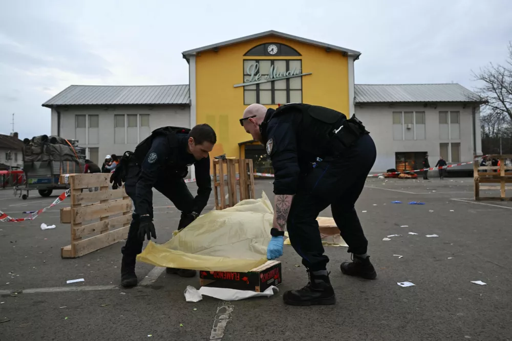 22 February 2025, France, Mulhouse: Police officers collect evidence at the site of a knife attack in Mulhouse. A man is suspected of killing one person and wounding two municipal police officers at a market in Mulhouse. Photo: Sebastien Bozon/AFP/dpa