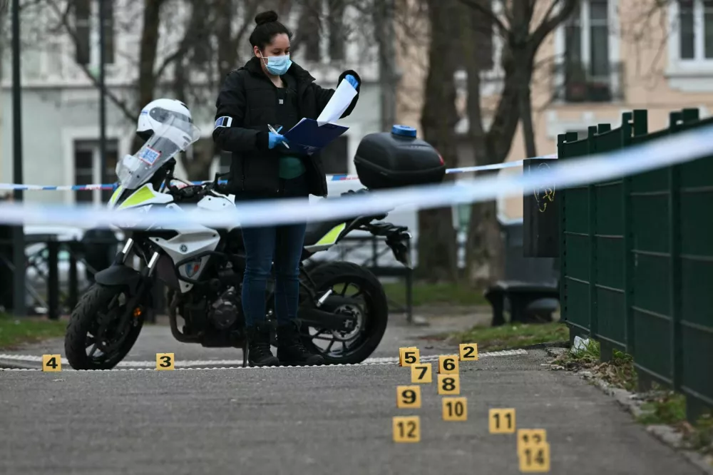 22 February 2025, France, Mulhouse: A policewoman collects evidence at the site of a knife attack in Mulhouse. A man is suspected of killing one person and wounding two municipal police officers at a market in Mulhouse. Photo: Sebastien Bozon/AFP/dpa