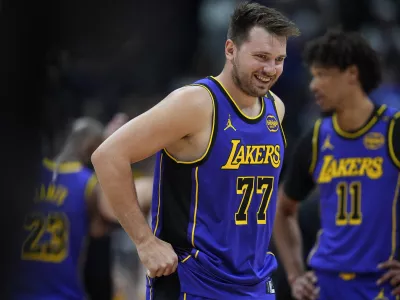 Los Angeles Lakers guard Luka Doncic laughs as he takes the court against the Denver Nuggets in the first half of an NBA basketball game Saturday, Feb. 22, 2025, in Denver. (AP Photo/David Zalubowski)