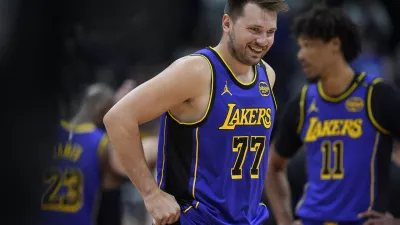 Los Angeles Lakers guard Luka Doncic laughs as he takes the court against the Denver Nuggets in the first half of an NBA basketball game Saturday, Feb. 22, 2025, in Denver. (AP Photo/David Zalubowski)