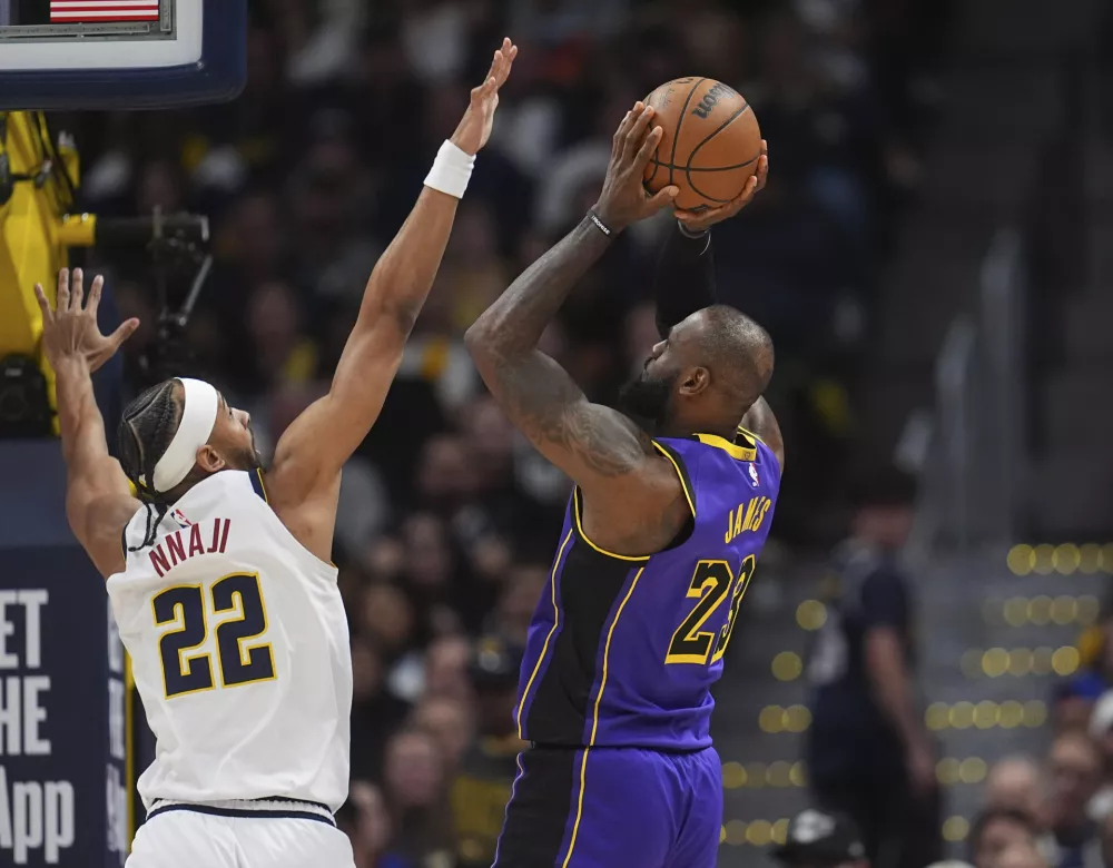 Los Angeles Lakers forward LeBron James, right, shoots for a basket over Denver Nuggets forward Zeke Nnaji in the second half of an NBA basketball game Saturday, Feb. 22, 2025, in Denver. (AP Photo/David Zalubowski)