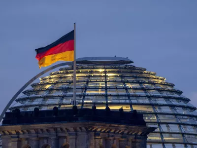 A German national flag waves on top of the Reichstag building in Berlin, Germany, Sunday, Feb. 23, 2025. (AP Photo/Michael Probst)