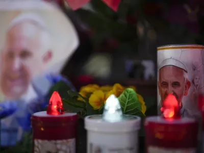 Candles are seen near pictures of Pope Francis outside the Agostino Gemelli Polyclinic in Rome, Sunday, Feb. 23, 2025, where the Pontiff is hospitalized since Feb. 14. (AP Photo/Gregorio Borgia)