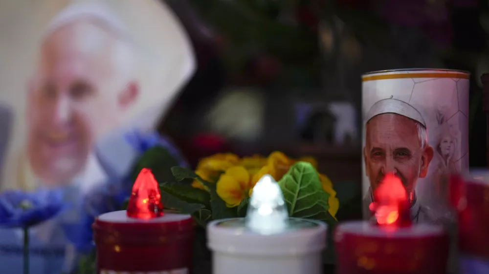 Candles are seen near pictures of Pope Francis outside the Agostino Gemelli Polyclinic in Rome, Sunday, Feb. 23, 2025, where the Pontiff is hospitalized since Feb. 14. (AP Photo/Gregorio Borgia)