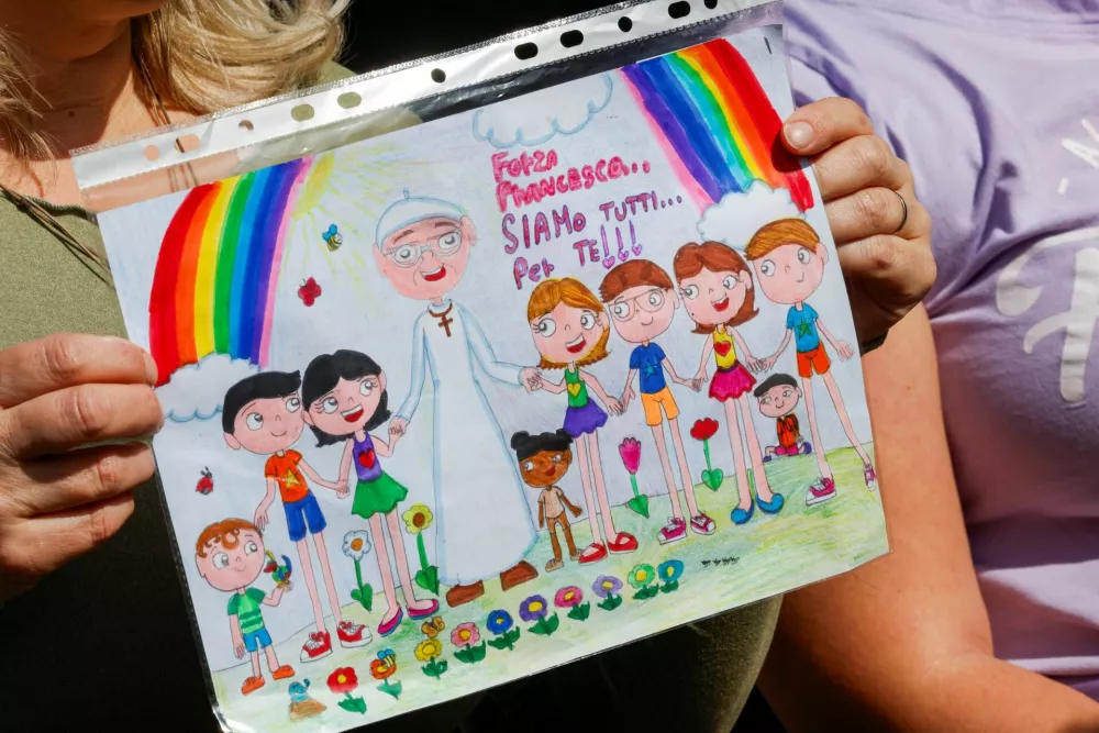 A person holds a drawing depicting Pope Francis outside the Gemelli Hospital where Pope Francis is admitted for treatment, in Rome, Italy, February 23, 2025. REUTERS/Ciro De Luca NO RESALES. NO ARCHIVES