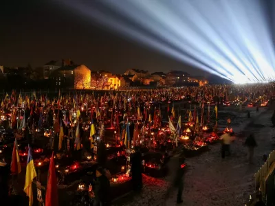 People visit the graves of their relatives, who were killed during Russia's attack on Ukraine, during a large-scale light installation "Lights of Memory" as they mark the third anniversary of the full-scale Russian invasion, at the Lychakiv cemetery in Lviv, Ukraine February 23, 2025. REUTERS/Roman Baluk