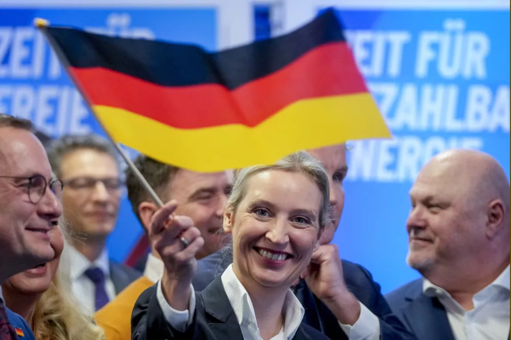 Kanclerska kandidatka Alternative za Nemčijo Alice Weidel je pomahala z zastavo in se nasmehnila ob uspehu stranke, ki je pristala na drugem mestu. Foto: AP