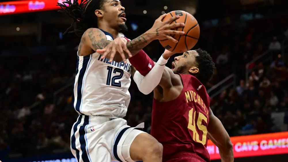 Feb 23, 2025; Cleveland, Ohio, USA; Memphis Grizzlies guard Ja Morant (12) is fouled by Cleveland Cavaliers guard Donovan Mitchell (45) during the second half at Rocket Arena. Mandatory Credit: Ken Blaze-Imagn Images