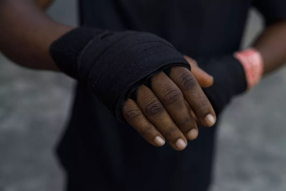 Abigail Kwartekaa Quartey wraps a bandage on her hand before a training session at a school compound in the Jamestown district in Accra, Ghana, Wednesday, Jan. 22, 2025. (AP Photo/Misper Apawu)