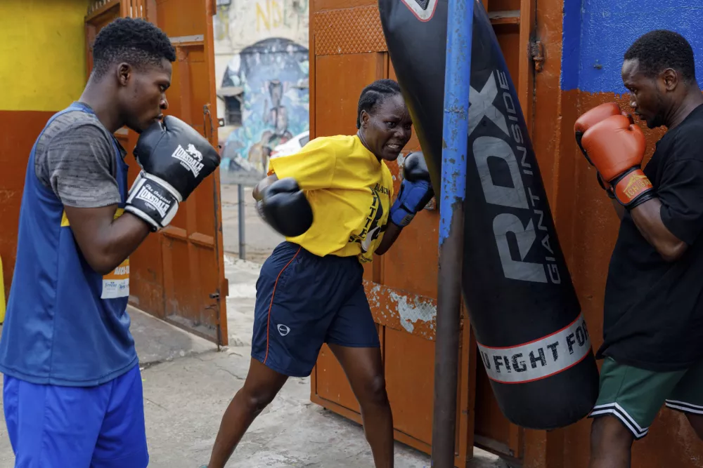 Abigail Kwartekaa Quartey, center, and other boxers train in a school compound in the Jamestown district in Accra, Ghana, Wednesday, Jan 22, 2025. (AP Photo/Misper Apawu)