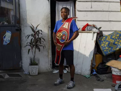 Ghana's first-ever female world boxing champion, Abigail Kwartekaa Quartey, poses for a photo with her world title belt at her house in the Jamestown district in Accra, Ghana, Wednesday, Jan. 22, 2025. (AP Photo/Misper Apawu)