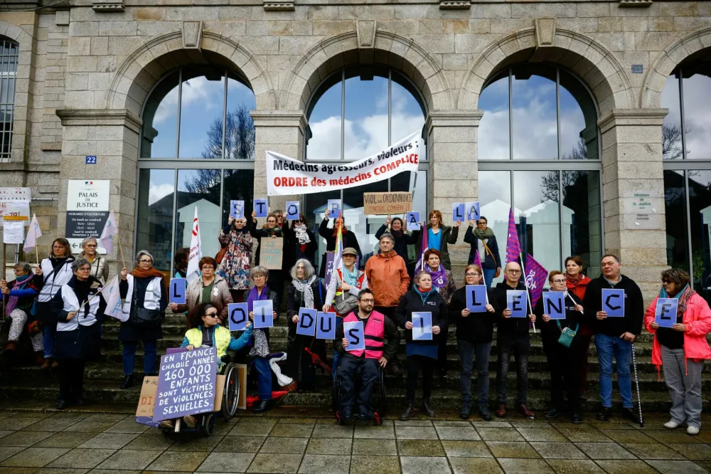 Members of women's collectives, doctors, NGOs and unions demonstrate in front of the courthouse on the opening day of the trial, where French ex-surgeon Joel Le Scouarnec is accused of aggravated rape and sexual assault against hundreds of children over three decades, at the courthouse in Vannes, Brittany, France, February 24, 2025. REUTERS/Stephane Mahe