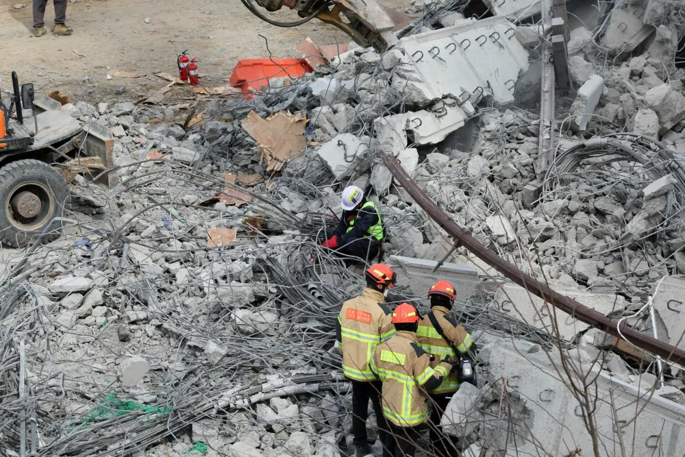 Rescue workers participate in a salvage operation at a collapsed highway construction site in Cheonan, South Korea, February 25, 2025.  REUTERS/Kim Hong-ji