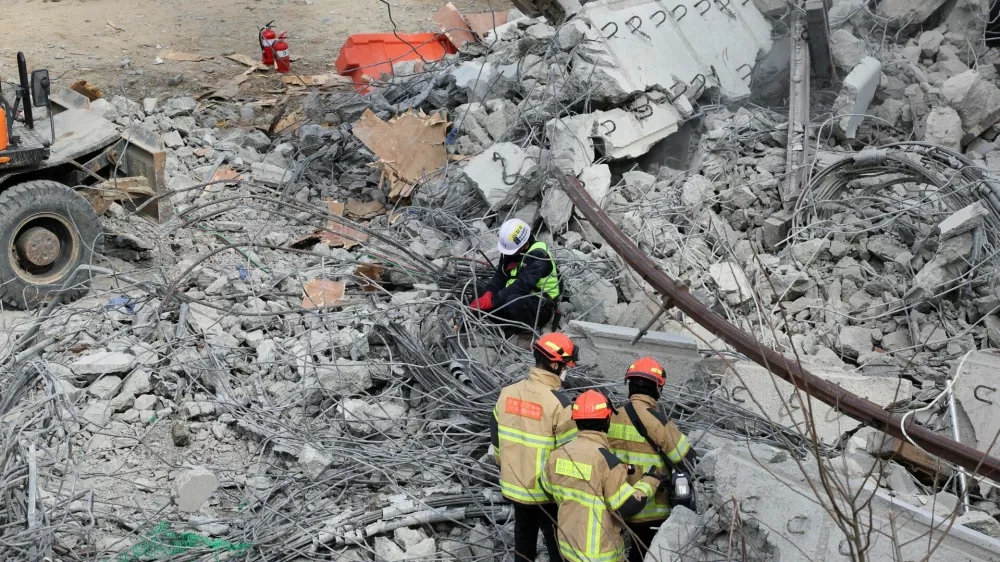 Rescue workers participate in a salvage operation at a collapsed highway construction site in Cheonan, South Korea, February 25, 2025.  REUTERS/Kim Hong-ji