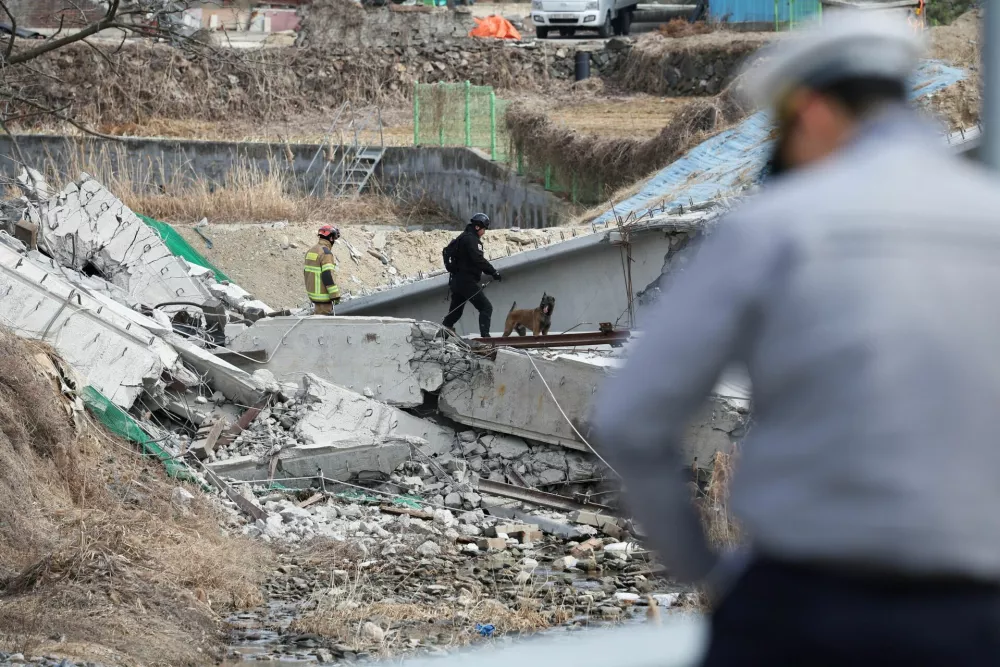 Rescue workers participate in a salvage operation at a collapsed highway construction site in Cheonan, South Korea, February 25, 2025.  REUTERS/Kim Hong-ji