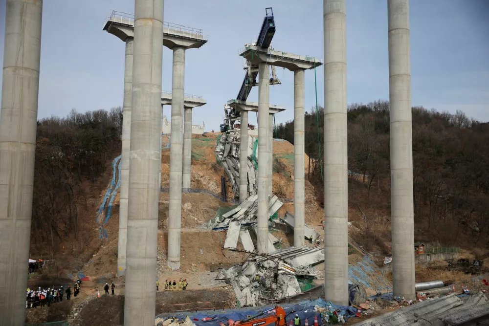 Rescue workers participate in a salvage operation at a collapsed highway construction site in Cheonan, South Korea, February 25, 2025.  REUTERS/Kim Hong-ji