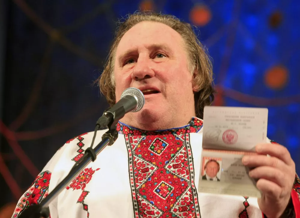 French film star Gerard Depardieu, wearing a local costume, shows his passport during a ceremony in the town of Saransk in the Mordoviya Republic, southeast of Moscow, January 6, 2013. Depardieu received a hug from Russia's President Vladimir Putin and a new Russian passport on Sunday after abandoning his homeland to avoid a new tax rate for millionaires. REUTERS/Yulia Chestnova (RUSSIA - Tags: ENTERTAINMENT POLITICS TPX IMAGES OF THE DAY)